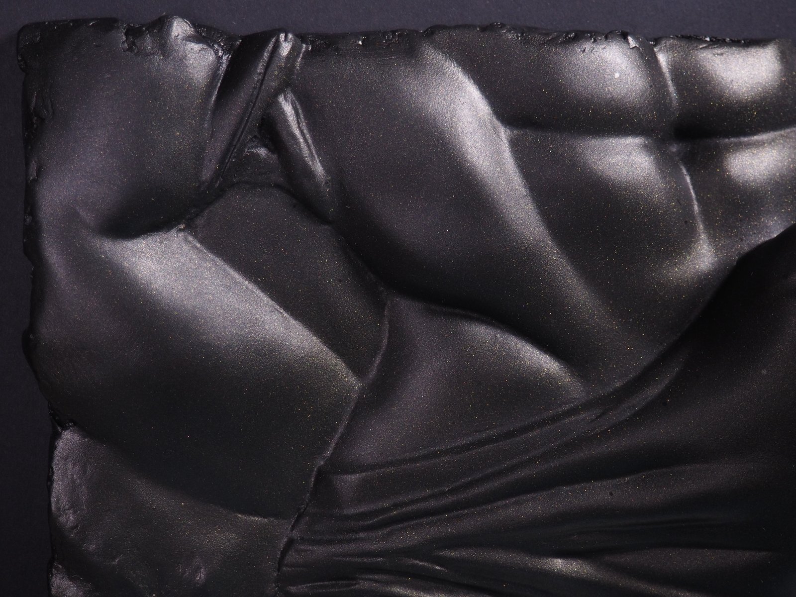 Detail view of The Shape of Want Black Gold resin sculpture